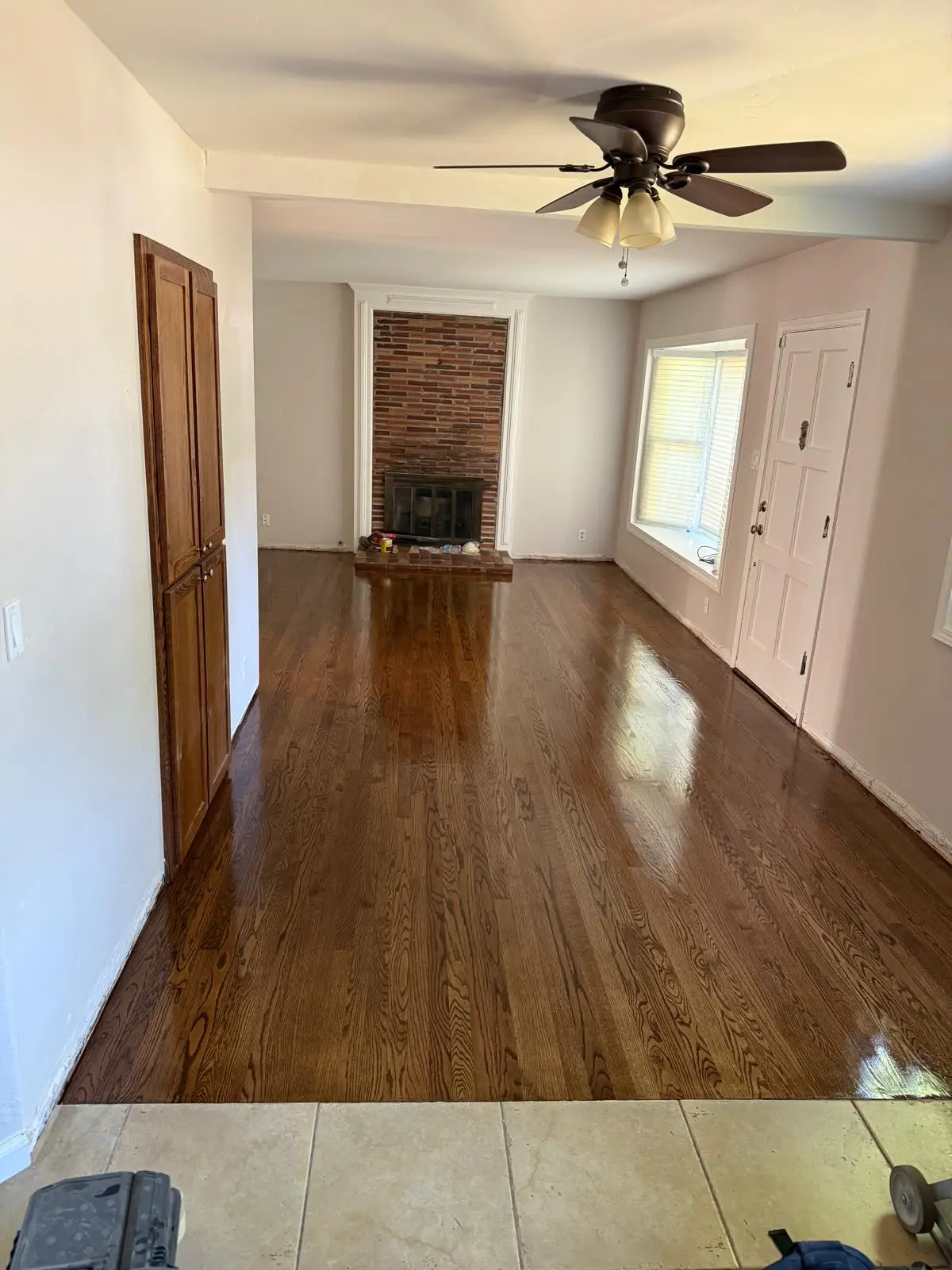 Refinished hardwood floor with medium brown stain and gloss finish in a Sacramento living room