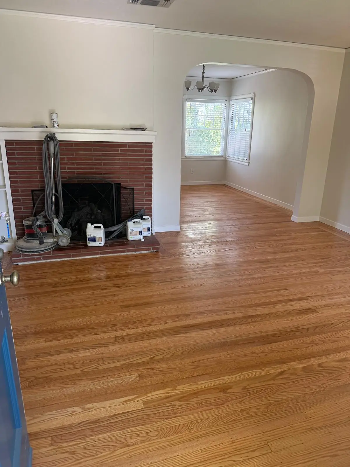Refinished red oak hardwood floors gleaming in a Fair Oaks living room