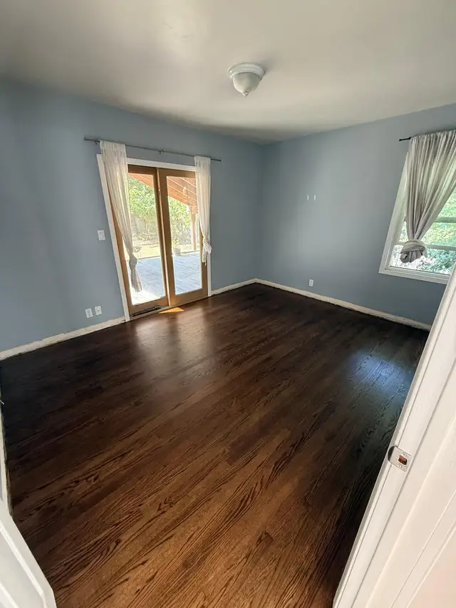 Bedroom hardwood floor refinishing result, dark walnut stained oak with smooth satin finish