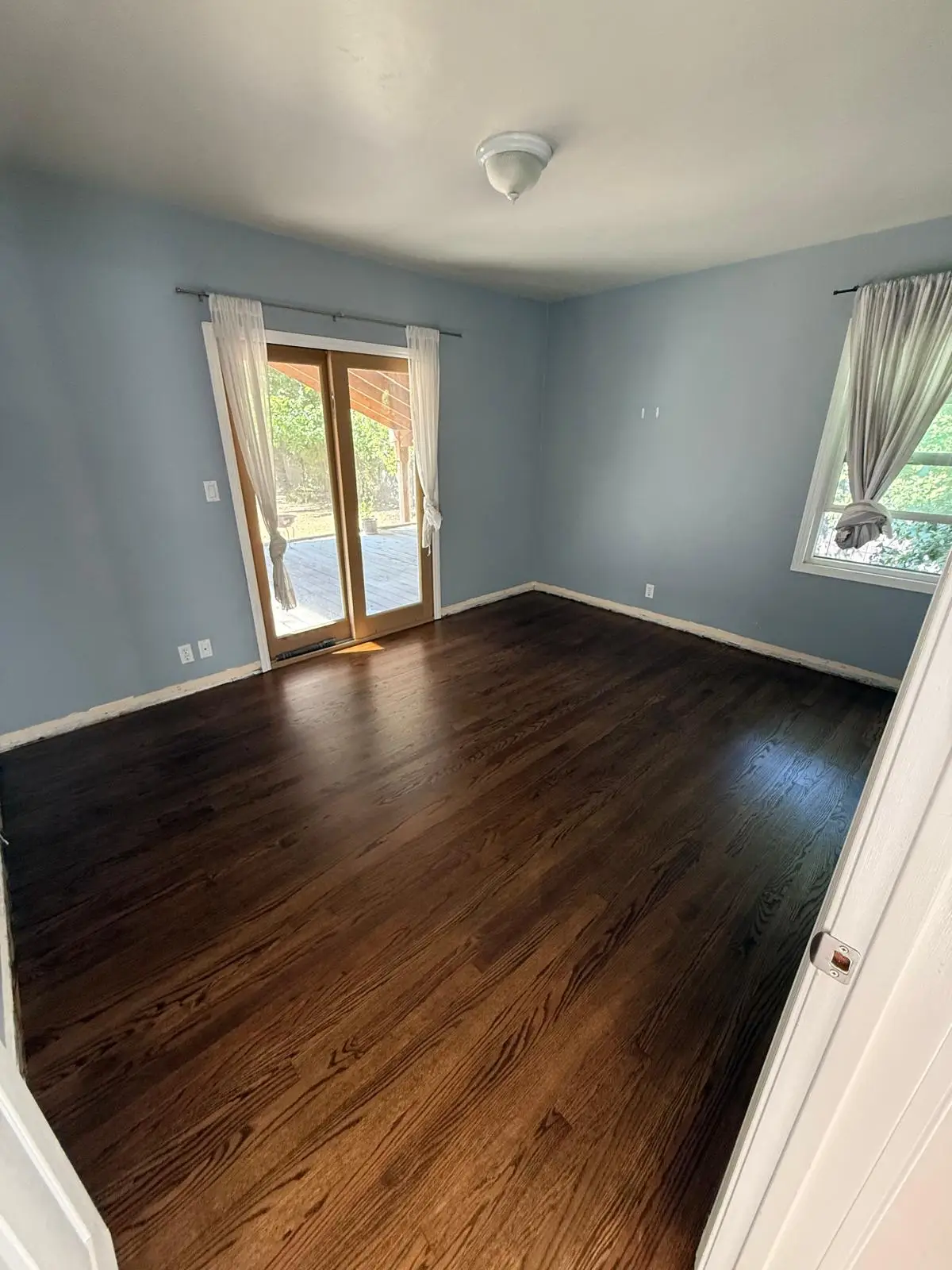 Bedroom hardwood floor refinishing result, dark walnut stained oak with smooth satin finish