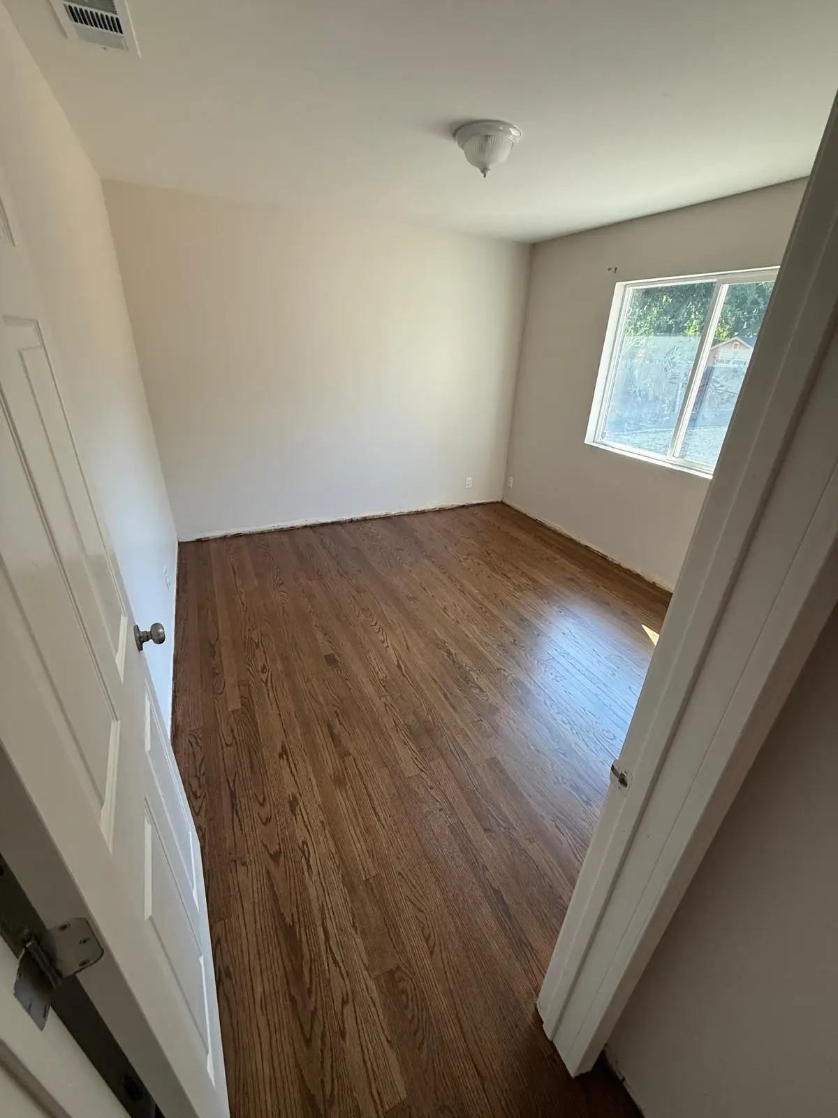 Hardwood floor refinishing in a Fair Oaks bedroom with warm-stained oak strips