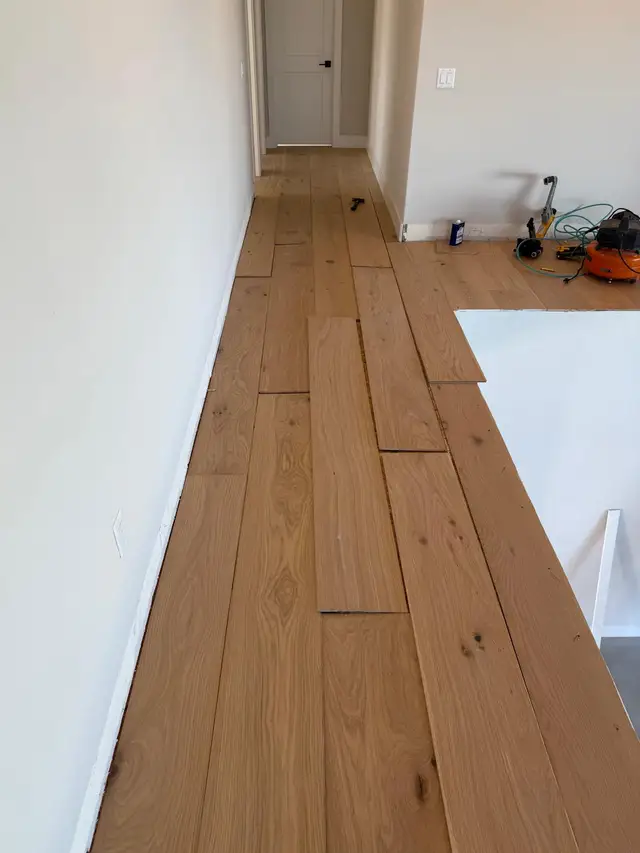 Wide plank oak hardwood floor installation in a hallway, Carmichael flooring project