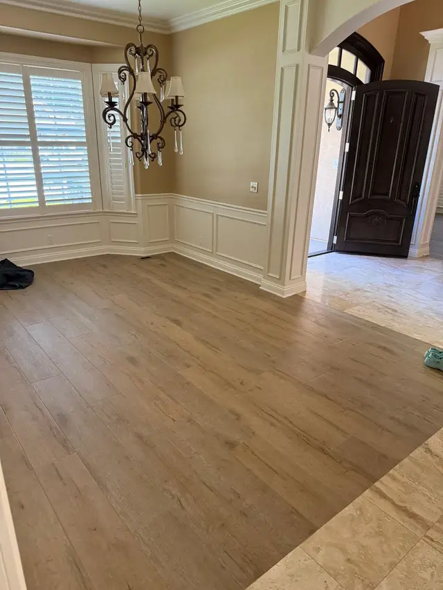 Wide-plank LVP flooring installation in a Rancho Cordova dining room with white wainscoting