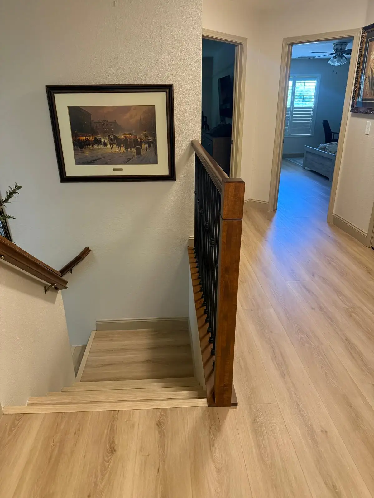 Wide plank LVP flooring installed in an upstairs hallway and staircase landing