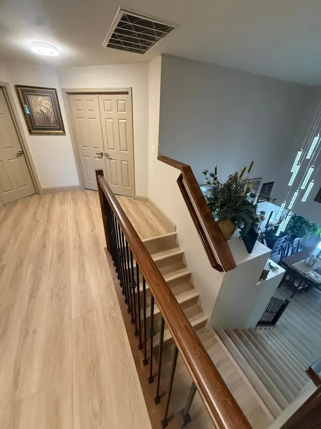 Light oak luxury vinyl plank flooring in upstairs hallway with new stair railing