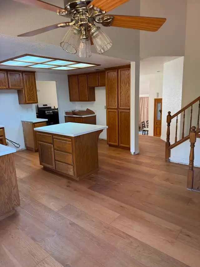 New LVP vinyl plank flooring installed through a kitchen and stair landing