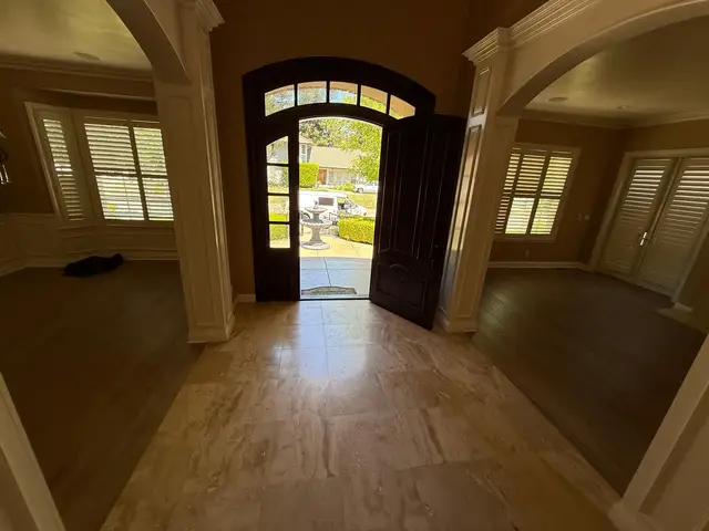 Luxury vinyl plank flooring meeting travertine tile in a home entryway