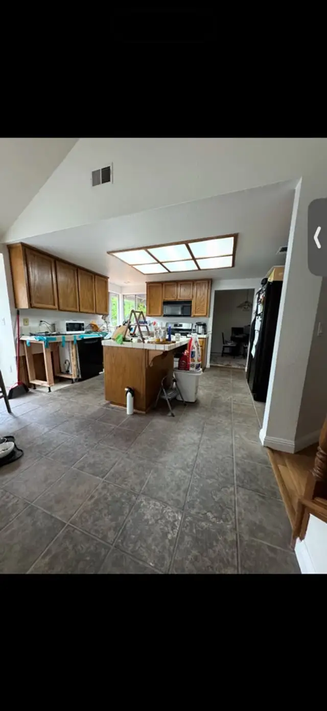 Kitchen with dated ceramic tile before vinyl plank flooring installation