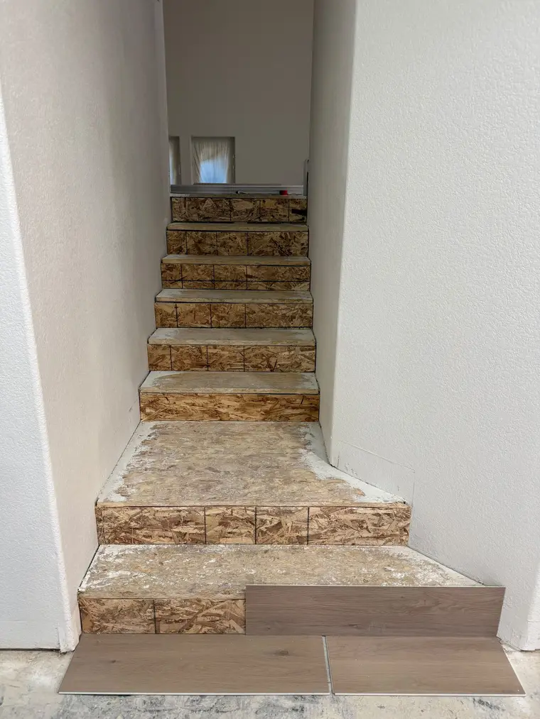 Before: Bare OSB winder staircase finished with wide oak-look plank treads