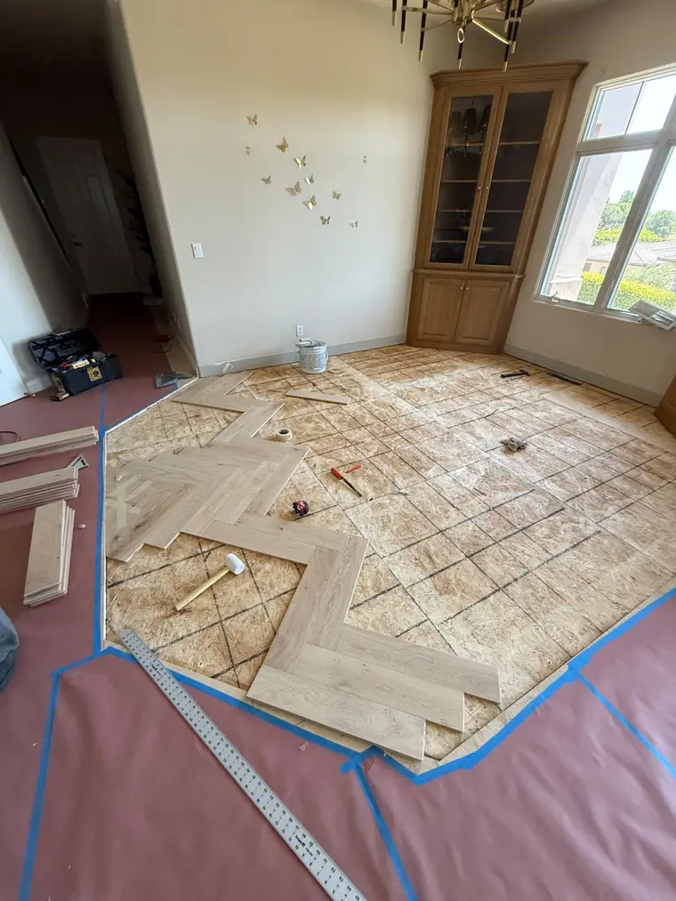 Before: White oak herringbone installed over a fresh subfloor in the front room