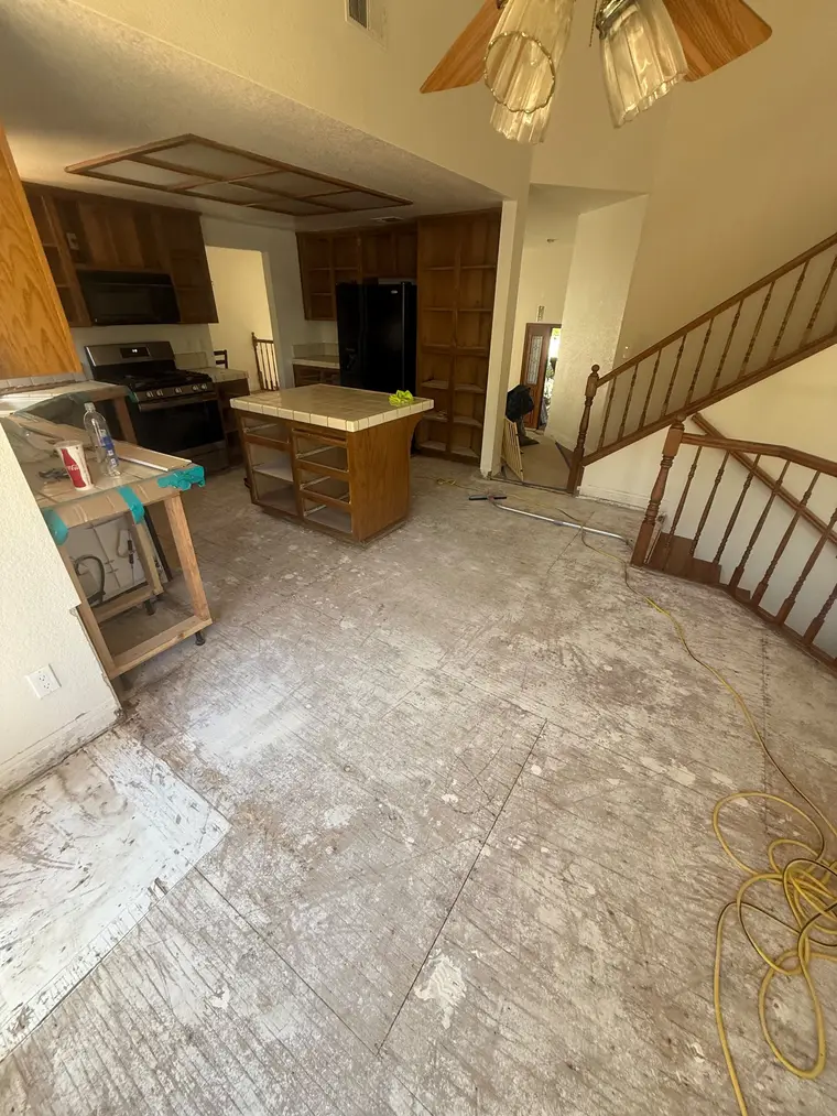 Before: Gutted kitchen subfloor transformed with wide plank oak look flooring