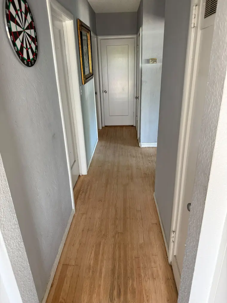 After: Worn, stained hallway oak sanded and refinished to a warm natural glow