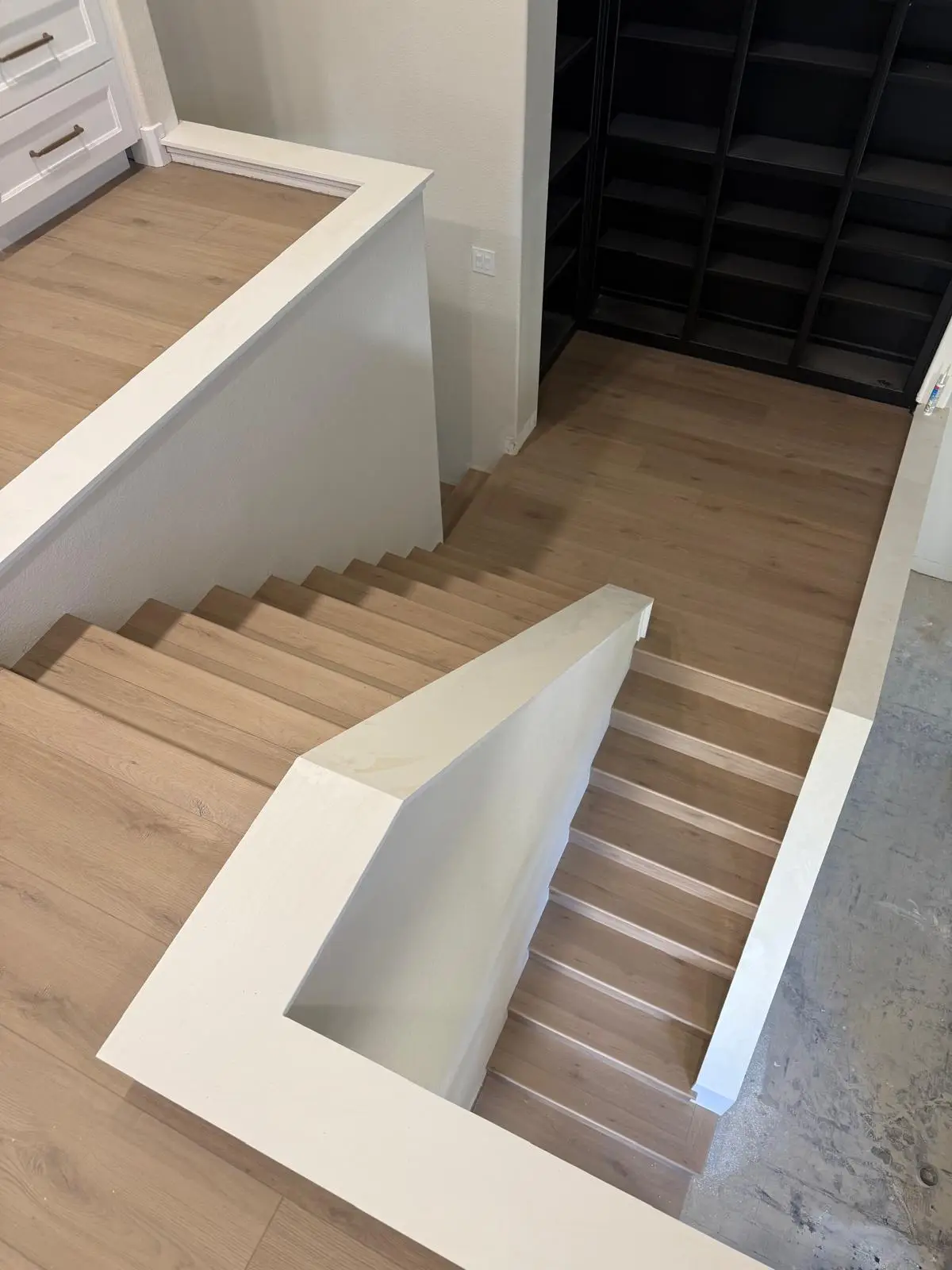 Light oak LVP stair installation with modern black metal railing in Roseville