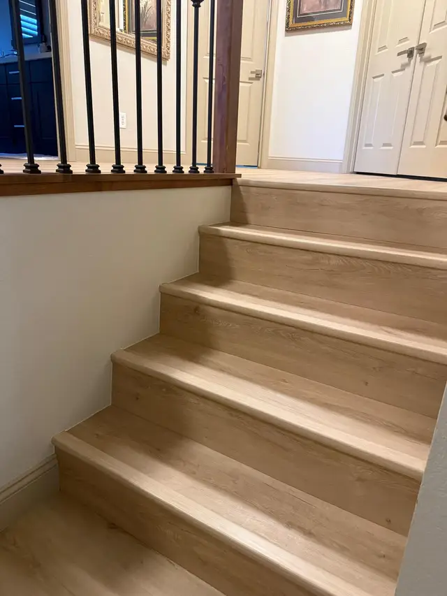 Light oak vinyl plank stair treads and risers installed on a home staircase