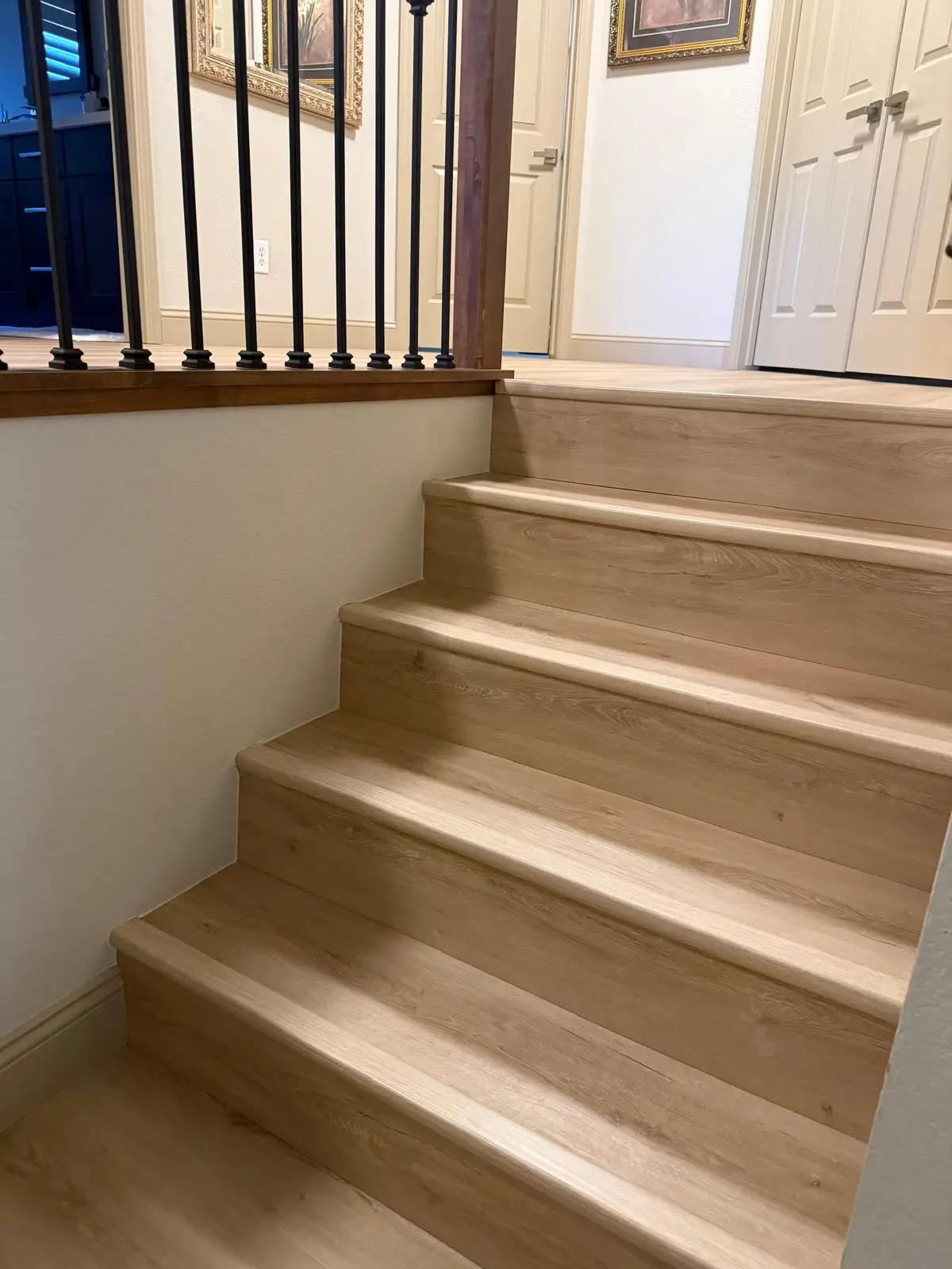 Light oak vinyl plank stair treads and risers installed on a home staircase