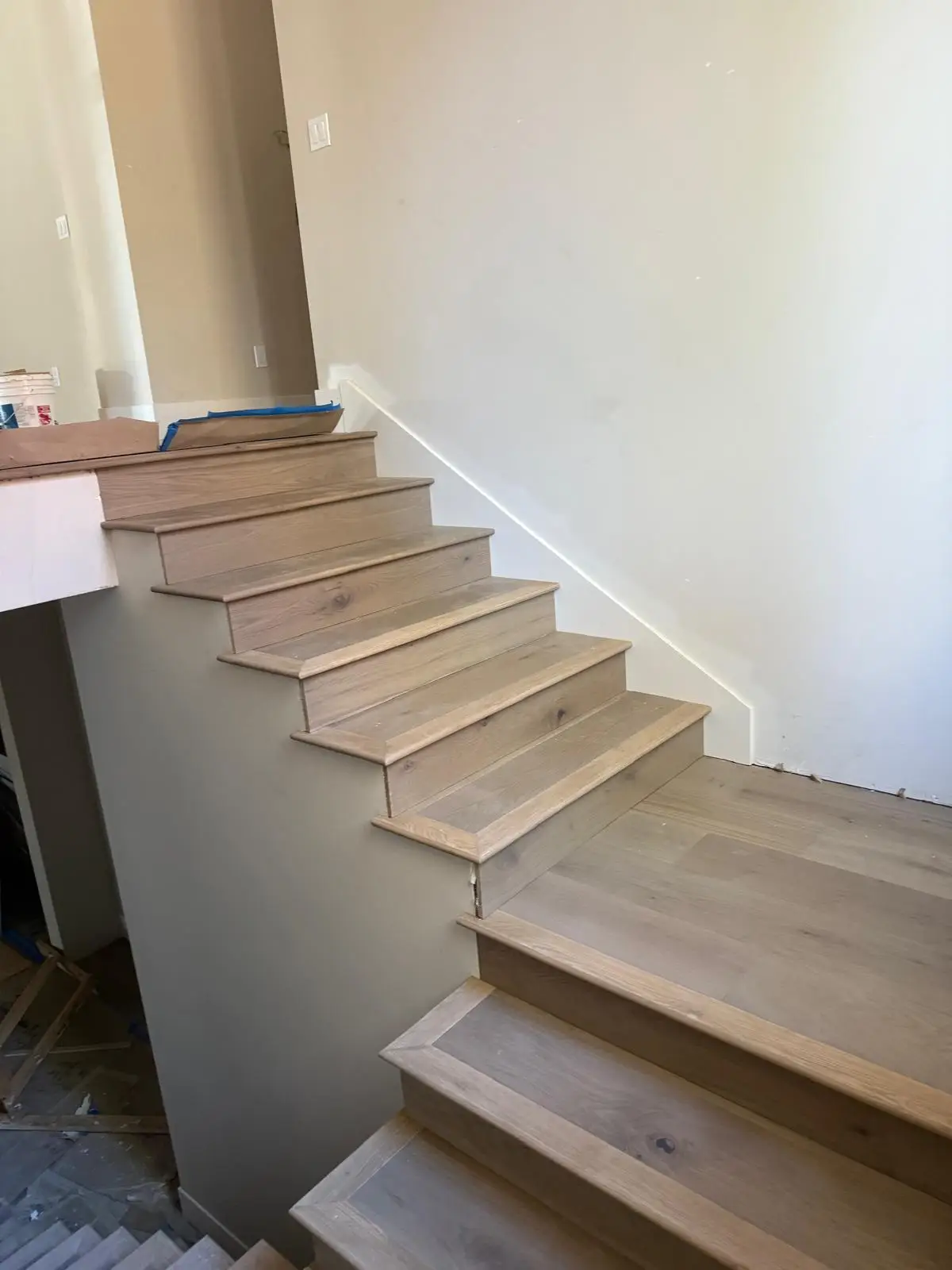 New white oak stair treads installed to match wide-plank hardwood flooring