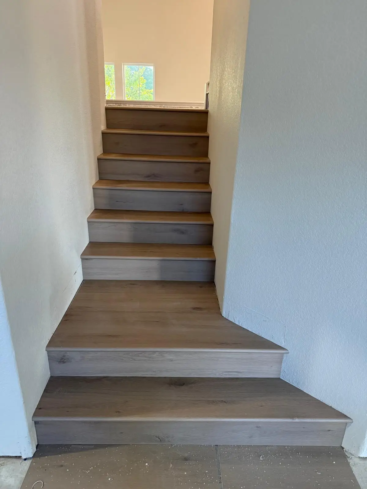 Finished staircase with LVP plank treads and risers installed in a Roseville home