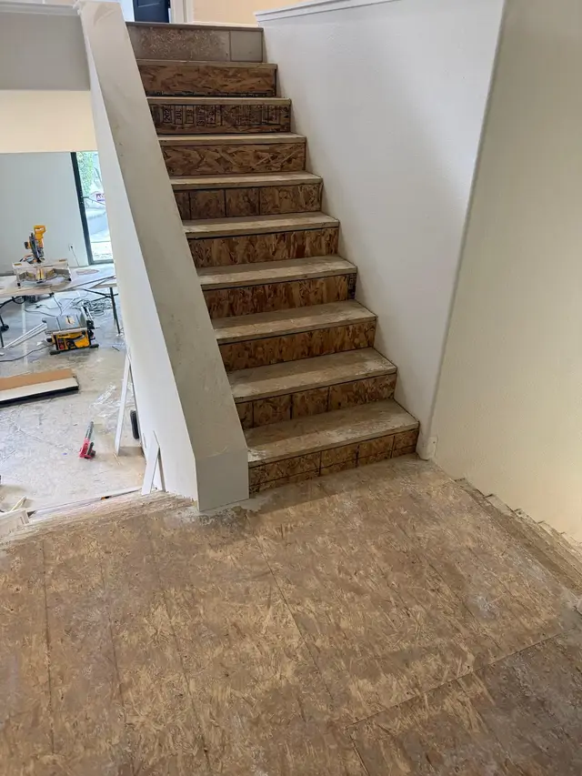 Stair tread installation in progress with oak steps fitted over subfloor risers
